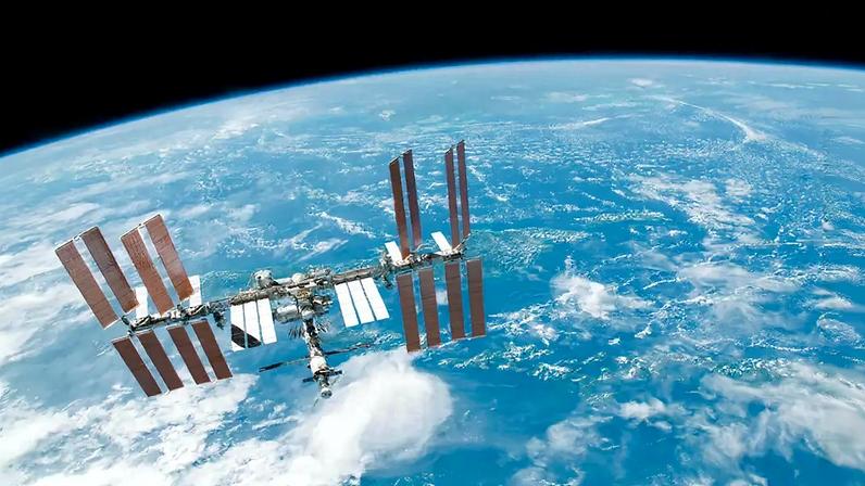 Fotografia da Estação Espacial Internacional tendo como pano de fundo o horizonte da Terra e a escuridão do espaço.