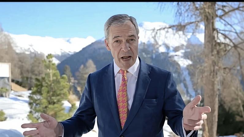Nigel Farage in Davos: a screengrab of him giving a speech with his arms outstretched and hands held up. He stands against a backdrop of snow, mountains and tall trees.
