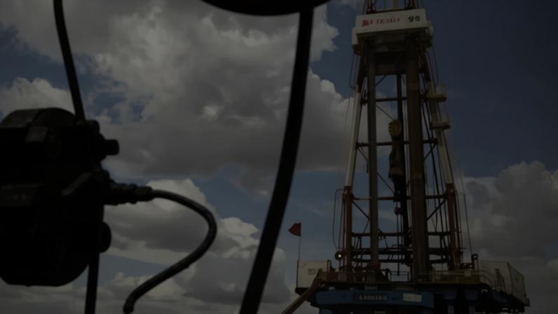 Crude oil drips from a valve at an oil well in Venezuela. Oil producers continue to pump more crude than needed by the global economy.