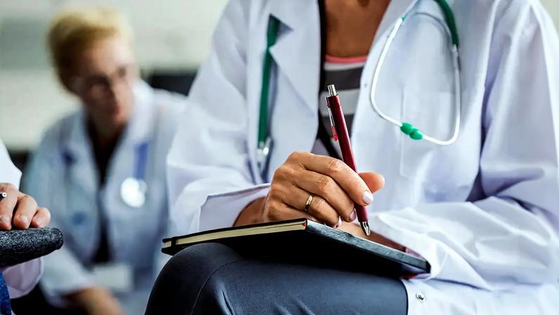 Fotografia de estudantes de medicina com cadernos para fazer anotações.