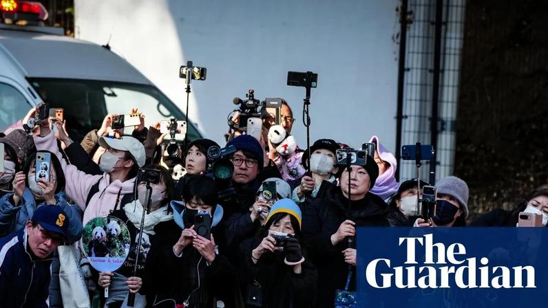 People bid farewell to the twin giant pandas Xiao Xiao and Lei Lei outside the Ueno zoological gardens in Tokyo.