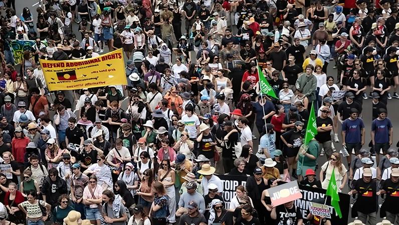 People march past Central Station during the Invasion Day rally in Sydney on 26 January.