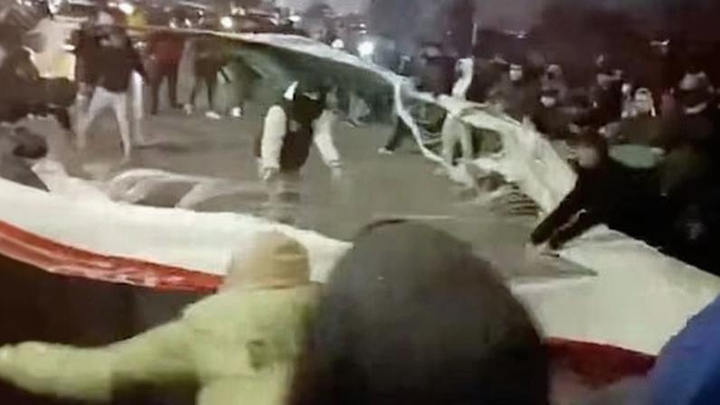 Manifestantes rompiendo una bandera de Irán en Mashhad este jueves, en una imagen obtenida de un vídeo de redes sociales.