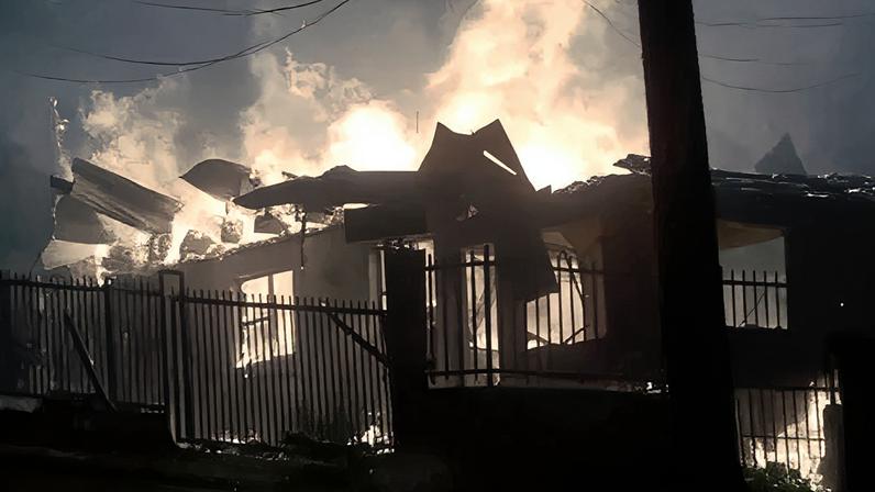 Houses affected by forest fires burn in Penco, Chile, 18 January 2026.