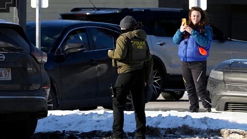 A woman films a Homeland Security Investigations agent in Portland, Maine, on 23 January 2026.