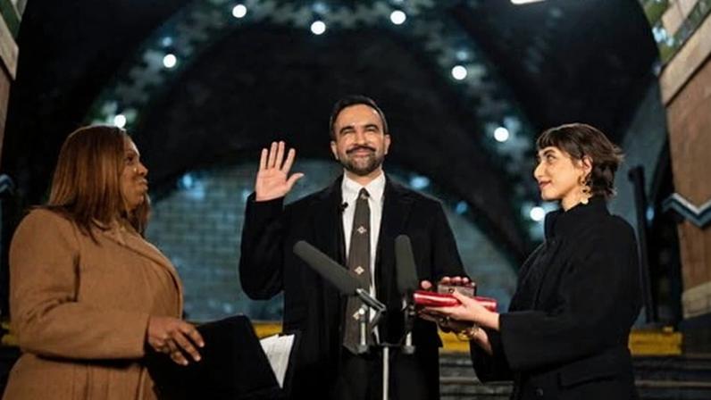Zohran Mamdani being sworn in as New York mayor on New Year’s Day, wearing a black overcoat and an Eri silk tie.