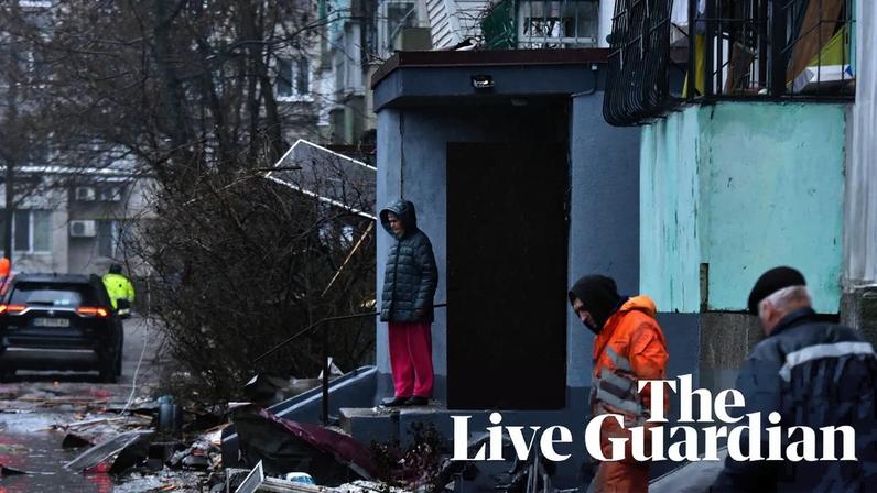 People stand among debris next to a damaged residential building following a drone attack in Dnipro amid the Russian invasion in Ukraine.