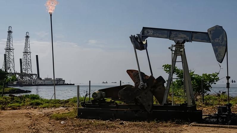 An oil pumpjack near water in Venezuela