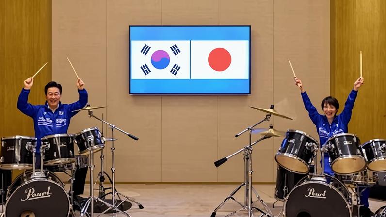 Japanese prime minister Sanae Takaichi and South Korean president Lee Jae Myung begin their drum session, playing along to Golden from K-Pop Demon Hunters, and BTS hit Dynamite.