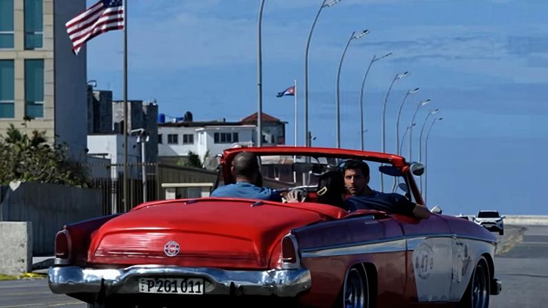A car driving past the US embassy in Havana.
