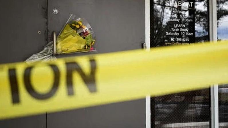 Caution tape and flowers cover the entrance to the Beth Israel Congregation in Jackson, Mississippi, on Monday.