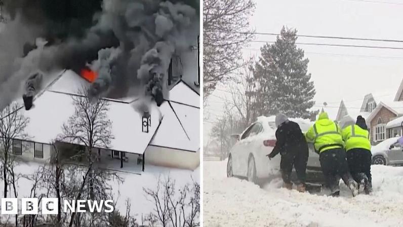 On the left, a house is on fire. On the right, we see three people pushing a vehicle.