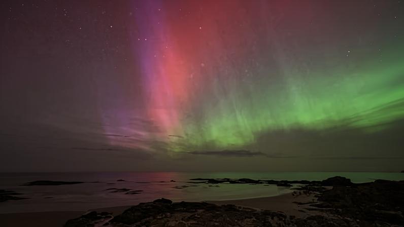 The aurora australis glows on the horizon over the waters of Brighton Beach in Dunedin.