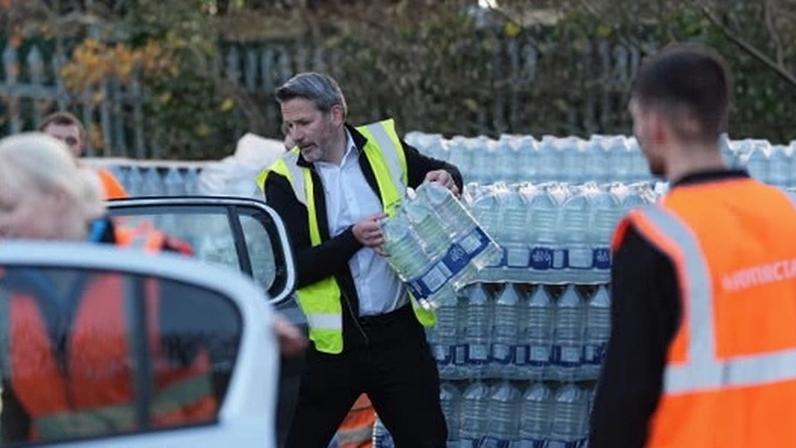 A worker hands out bottled water in Tunbridge Wells on 3 December 2025 during the last outage.