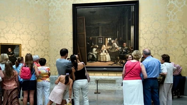 Visitors look at Las Meninas by Velázquez in the Prado.