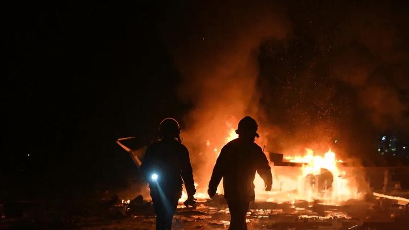 Ukrainian firefighters following an air strike in a village outside of Kharkiv on 13 January, 2026.
