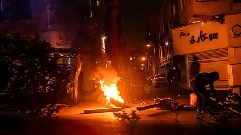 Iranians gather while blocking a street during the protests in Tehran