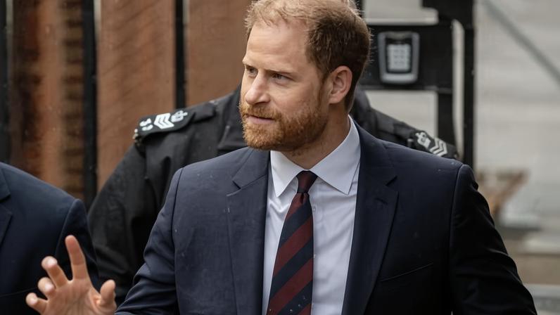 Prince Harry waves as he arrives at court