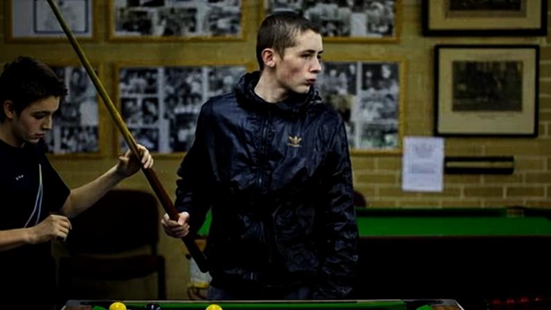 Two boys playing snooker in a youth club