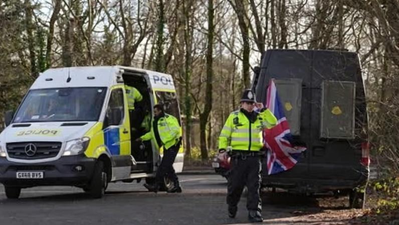 Police officers outside the Crowborough training camp, East Sussex, where the first 27 illegal migrants have now moved in as part of the government's mission to end the use of expensive hotels.