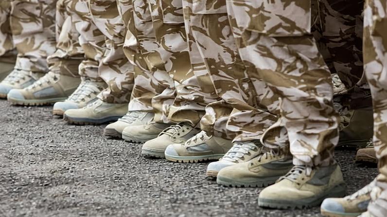 Boots and camouflage trousers of soldiers standing in a row