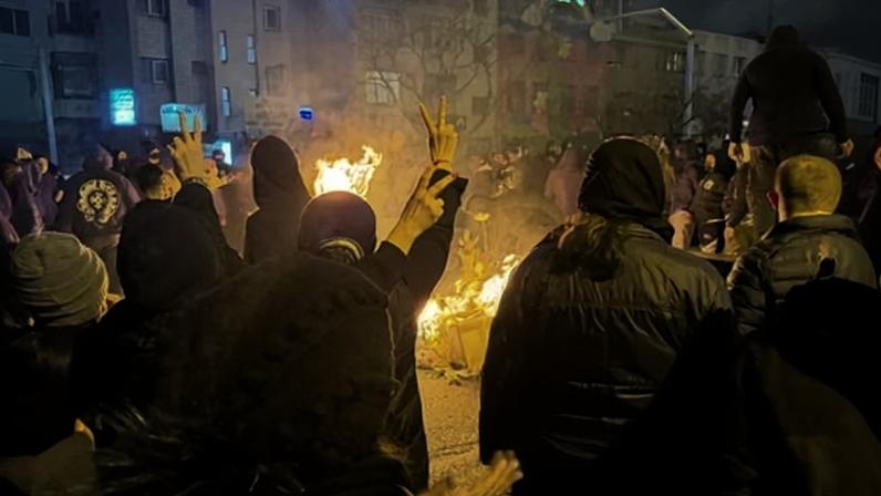 Protesters gather around a fire in Tehran, Iran.