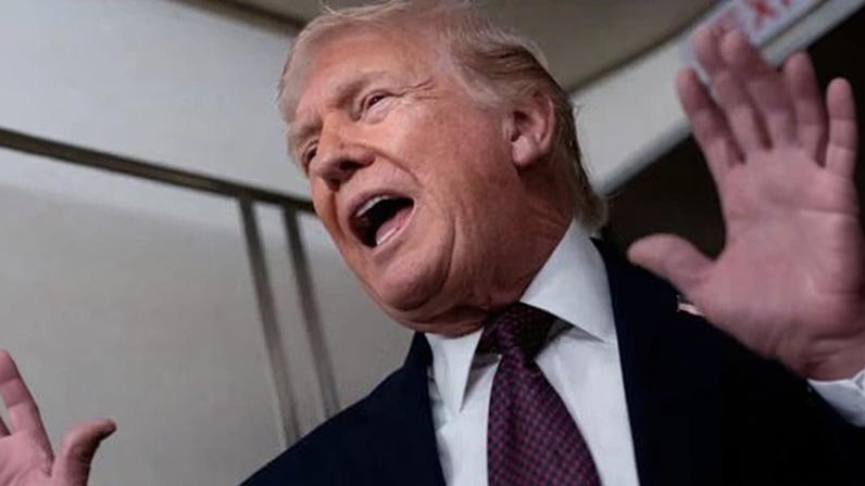 US president Donald Trump speaks with members of the media aboard Air Force One on 11 January, 2026.