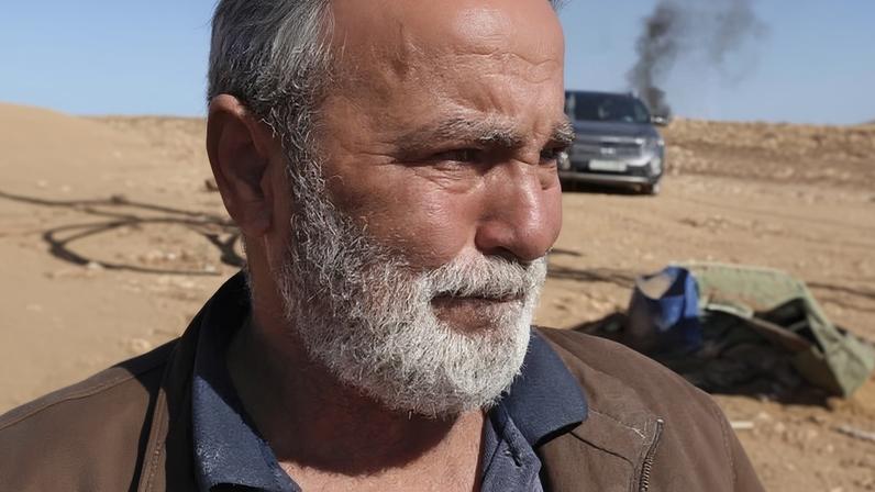 Mahmoud Eshaq cries while watching his family packing their belongings as they prepare to leave their home.