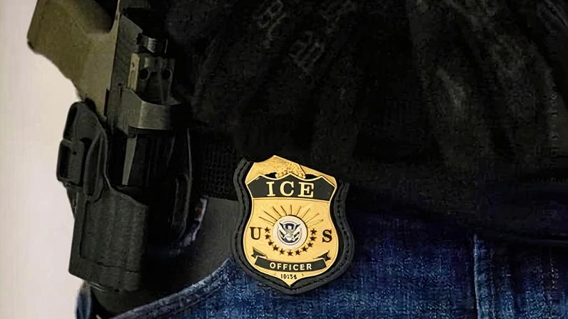 A federal agent wears an Immigration and Customs Enforcement badge at the immigration court in New York in June 2025.