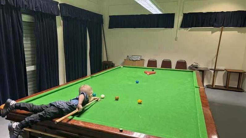Jude Owens attempting a snooker shot.