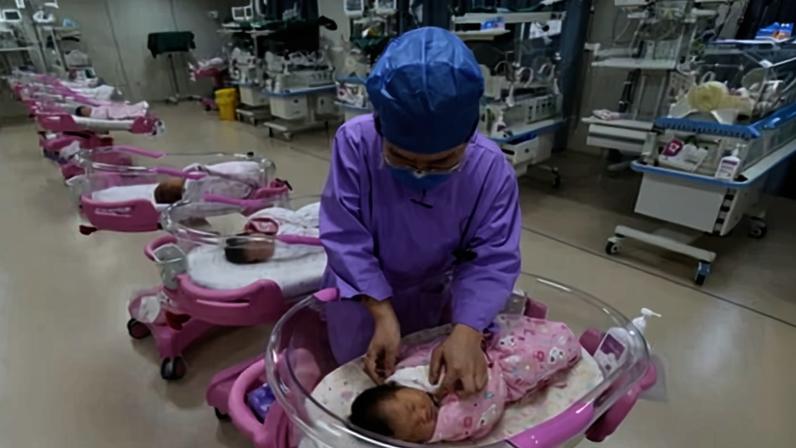A nurse takes care of newborn babies in a maternity hospital in Anhui province, China.