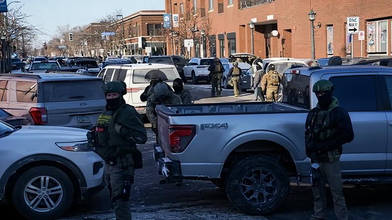 Federal agents stand guard at the scene of the shooting in south Minneapolis, Minnesota, on Saturday.