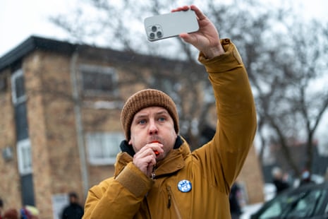 An observer blows a whistle as border patrol agents arrest two teenagers after a car crash in south Minneapolis on 21 January 2026.