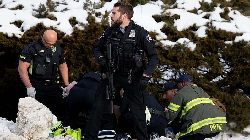 A Minneapolis police officer stands guard while emergency medical technicians administer aid to a person who was shot by a Immigration and Customs Enforcement officer in Minneapolis on 07 Jan. 2026.