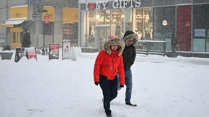 Getty Images Two people, dressed in thick coats, walk through the snow in New York City