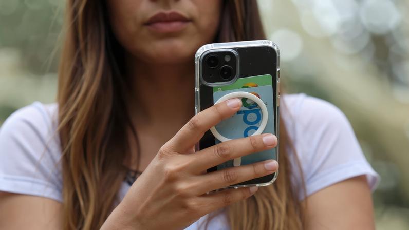 A teenager poses holding a mobile phone as law banning social media for users under 16 in Australia takes effect, in Sydney, Australia, December 10, 2025. REUTERS/Hollie Adams/File Photo