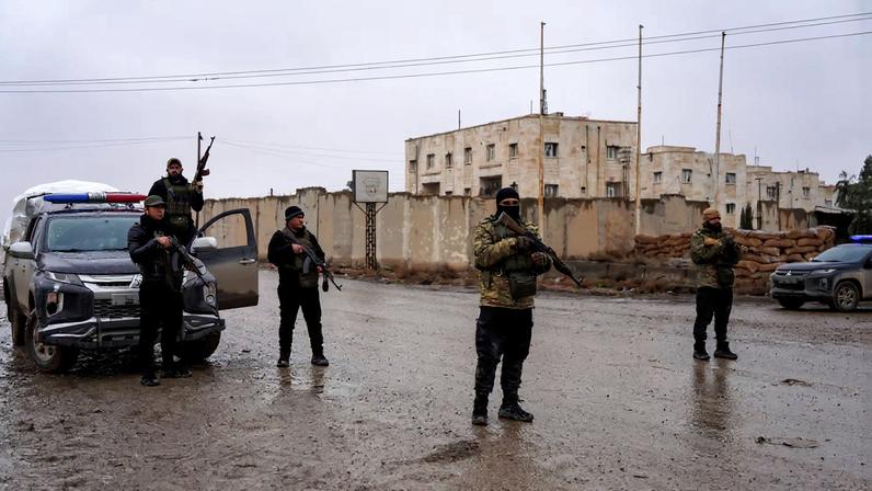 Members of the Syrian security forces stand guard outside al-Aqtan prison, where some Islamic State detainees are held, in Raqqa, Syria January 23, 2026. REUTERS/Karam al-Masri