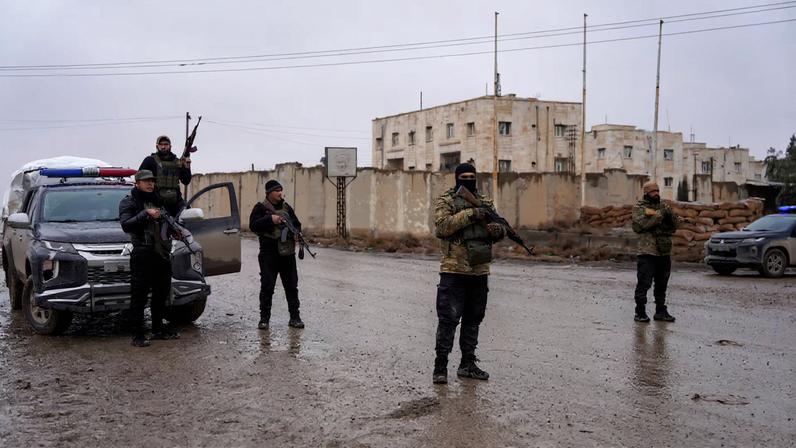 Members of the Syrian security forces stand guard outside al-Aqtan prison, where some Islamic State detainees are held, in Raqqa, Syria January 23, 2026. REUTERS/Karam al-Masri