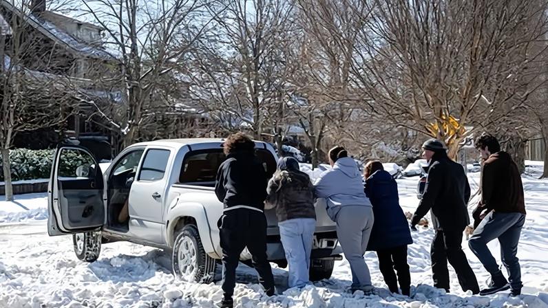 Community members gather to push a truck out of a snow pile following a major snow storm in Louisville, Kentucky, on Monday.