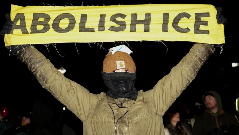 A person holds a banner as people march during a demonstration against increased immigration enforcement, days after the fatal shooting of Renee Nicole Good by a U.S. Immigration and Customs Enforcement (ICE) agent, in Minneapolis, Minnesota, U.S., January 9, 2026. REUTERS/Tim Evans/File Photo