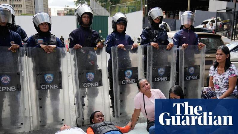 Relatives of political prisoners lie down in front of riot police guarding the Zona 7 detention centre in Caracas.