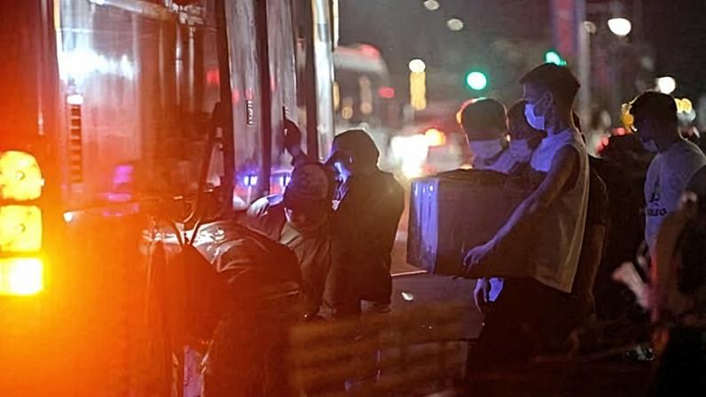 Workers carry their belongings onto a bus as they leave a suspected scam centre compound in Sihanoukville, Cambodia on 14 January.