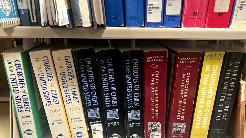 Previous editions of "Churches of Christ in the United States" sit on a bookshelf.