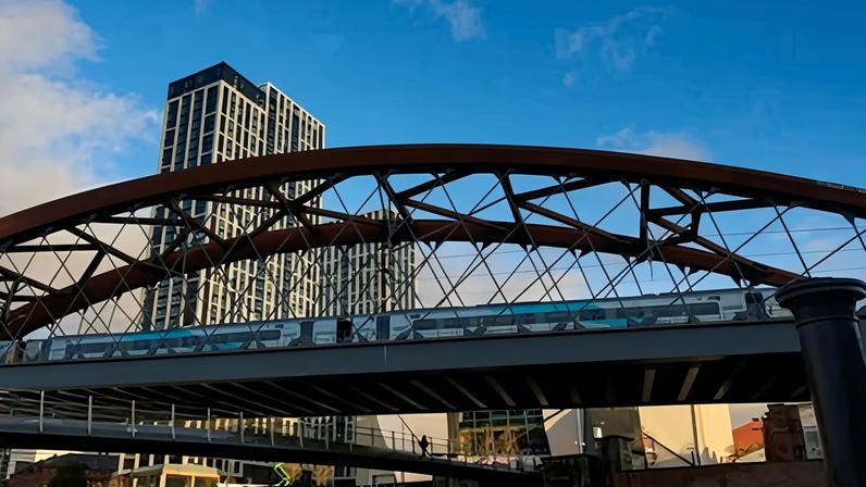 A train crosses a bridge over a waterway in Manchester. Work on a new line connecting the city to Birmingham is not expected to start until the 2040s.