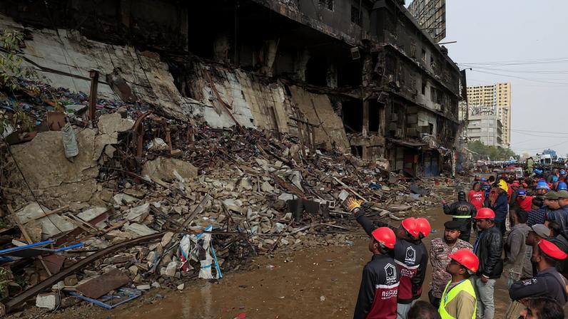 Emergency personnel survey the damaged portion of the building, following a massive fire that broke out in the Gul Plaza Shopping Mall in Karachi, Pakistan, January 19, 2026. REUTERS/Akhtar Soomro