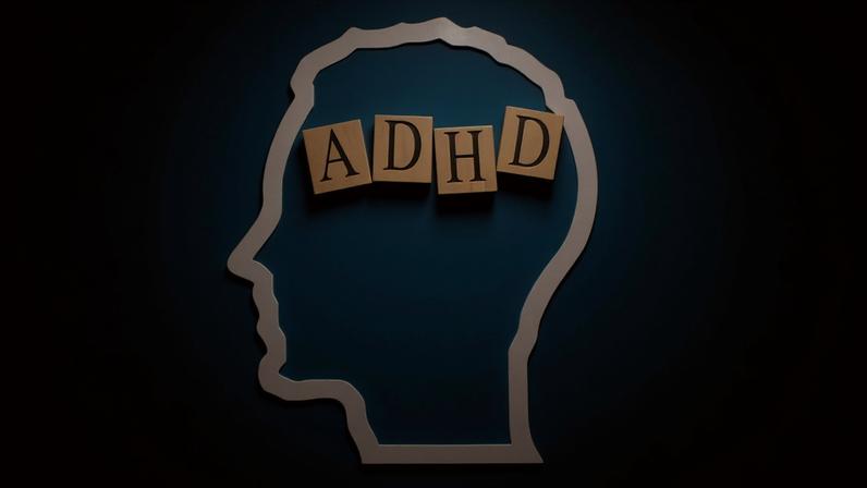 Letters of ADHD on outline of head.