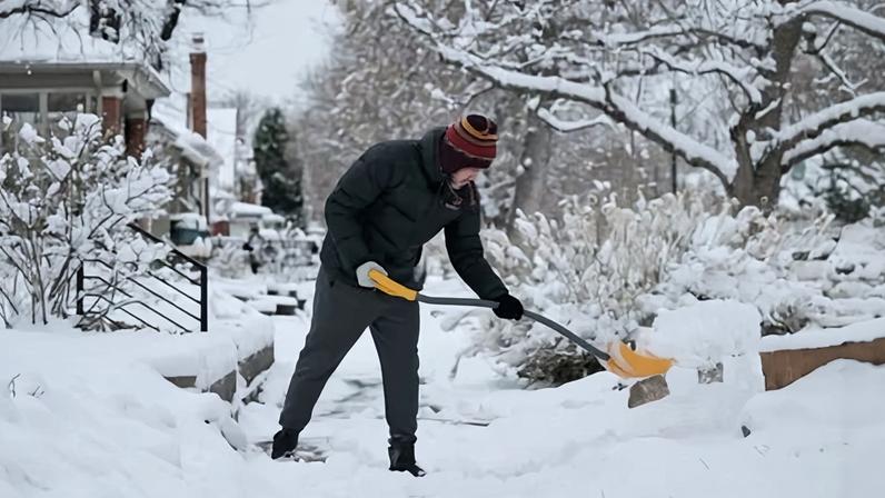 A man clears snow in front of his house in Denver, Colorado, on 9 January 2026.