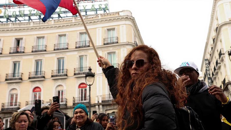 A woman waves a Venezuelan flag, as people react to the news after U.S. President Donald Trump said the U.S. has struck Venezuela and captured its President Nicolas Maduro, in Madrid, Spain, January 3, 2026. REUTERS/Violeta Santos Moura