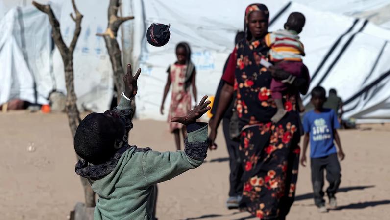 Sudanese refugee children from al-Fashir play the handmade sock ball at the Tine transit refugee camp in eastern Chad