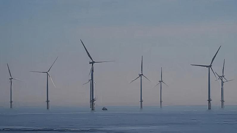 Getty Images Several wind turbines in the blue sea, with a grey-blue sky